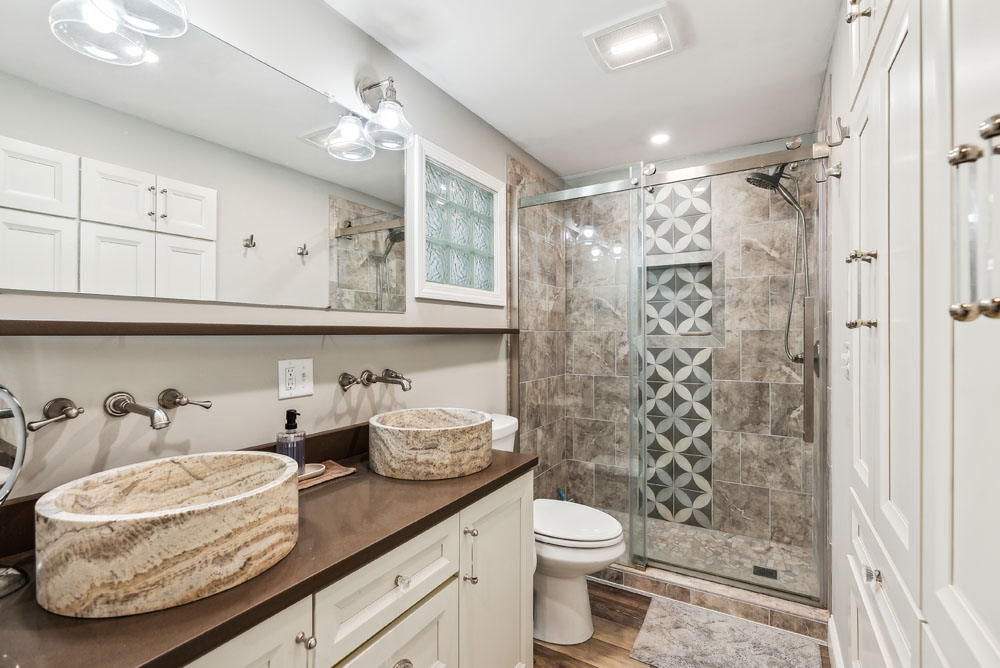 Full bathroom on upper level attached to primary bedroom with double vanity